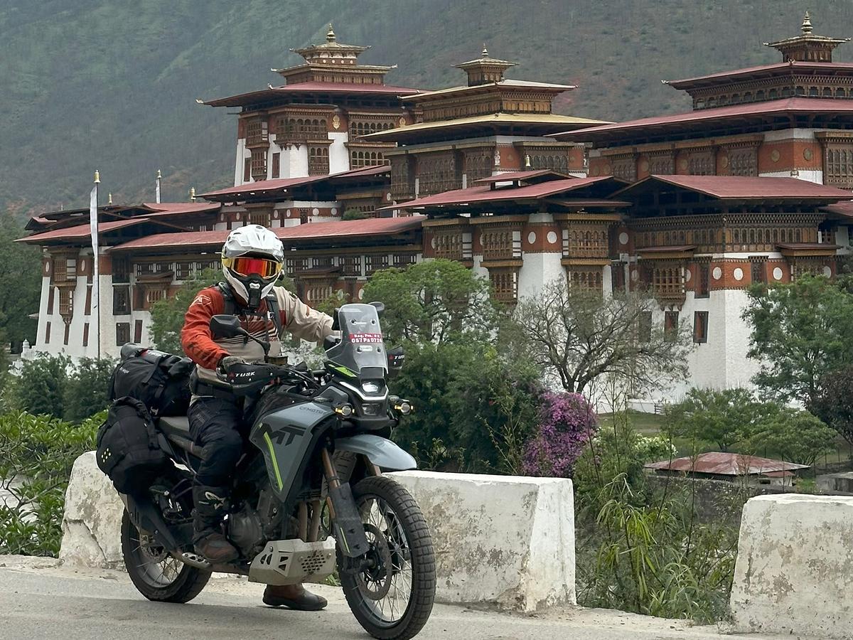 Motorcyclist in front of a Bhutanese monastery