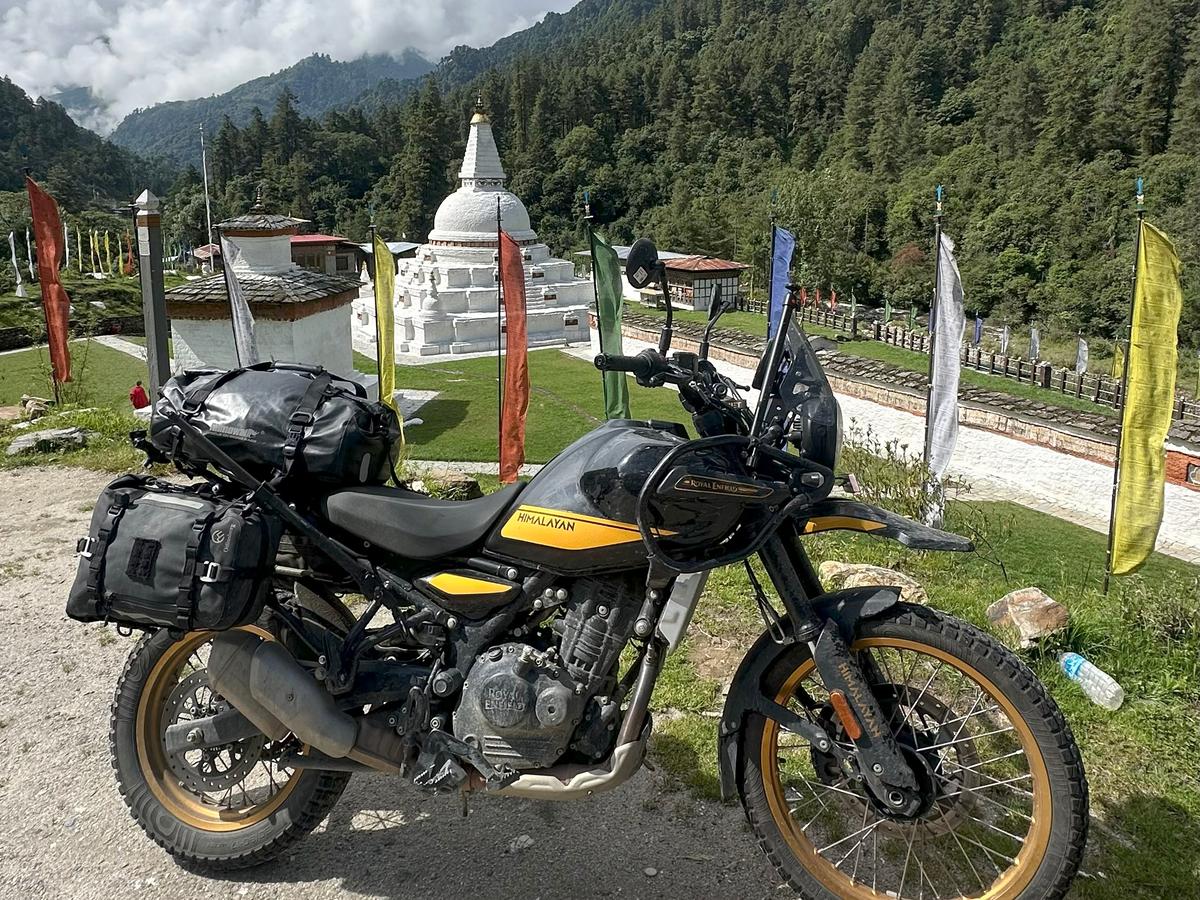 An adventure motorcycle parked near a stupa in Bhutan