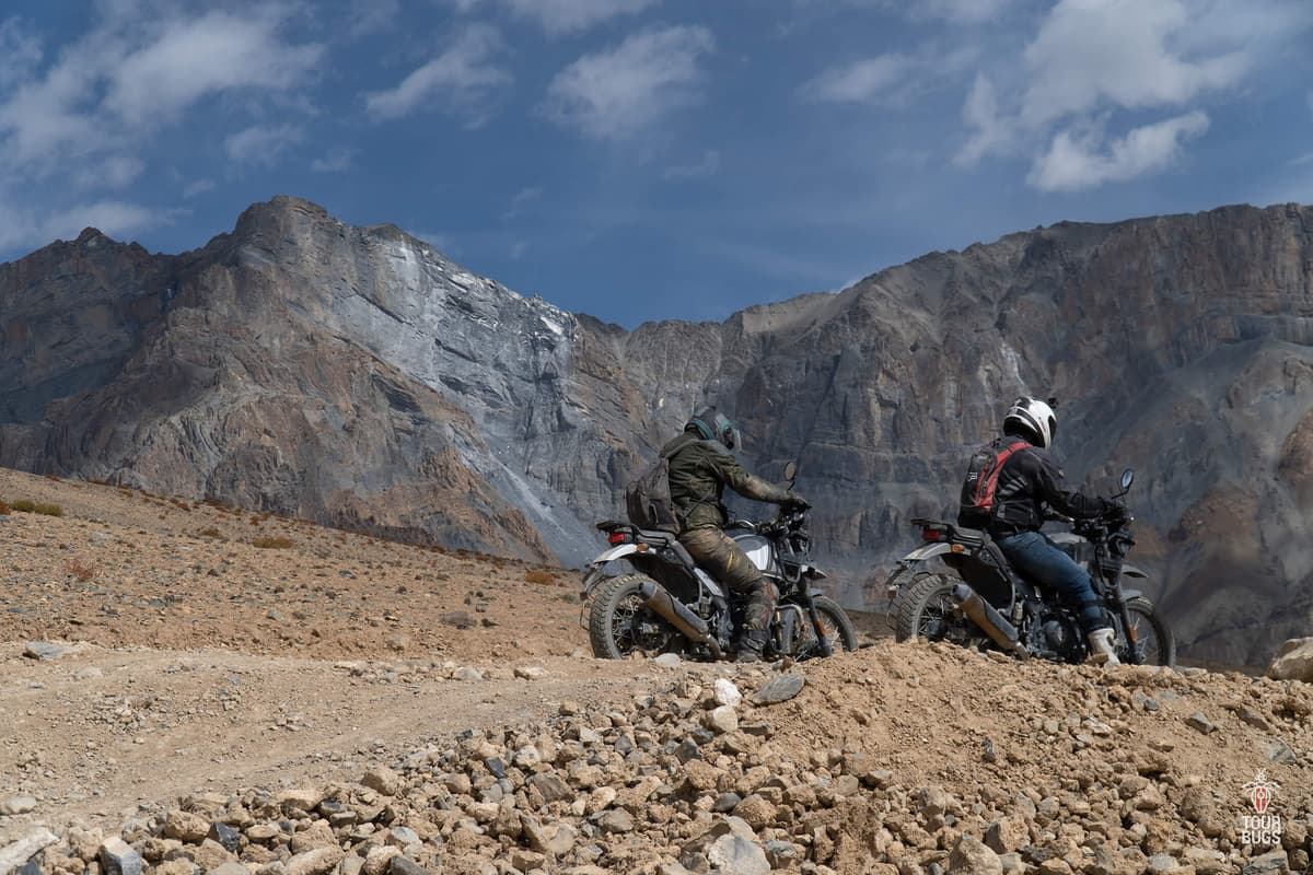 Two riders on adventure motorcycles in a mountainous landscape
