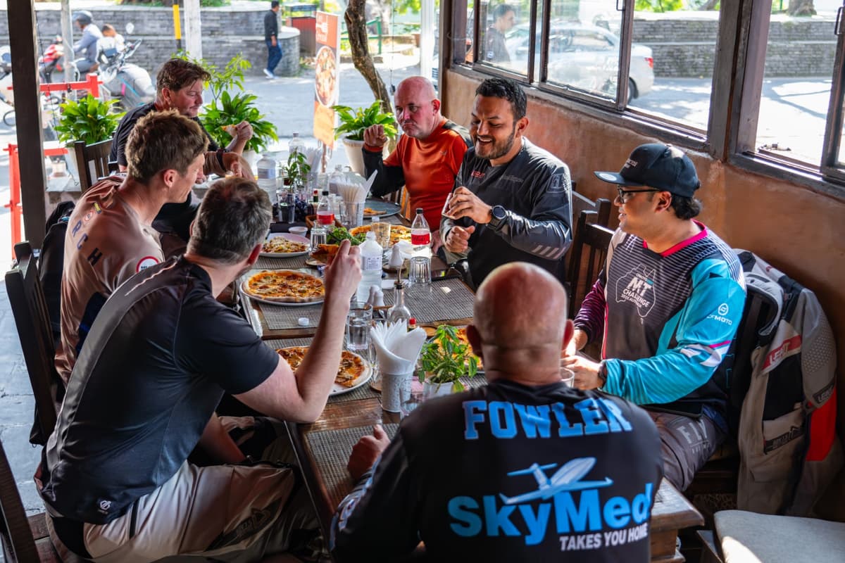Group of riders enjoying a meal together during our Nepal motorcycle tour.