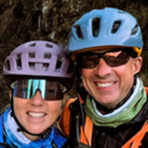 Portrait of Edwin C and another rider wearing helmets and sunglasses, smiling while geared up for our motorcycle tour.